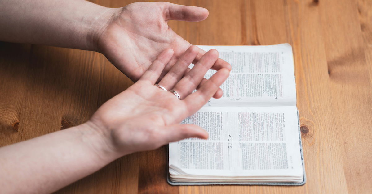 Hands over Bible