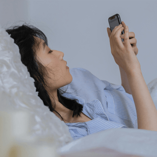 Woman Lying in Bed on Phone